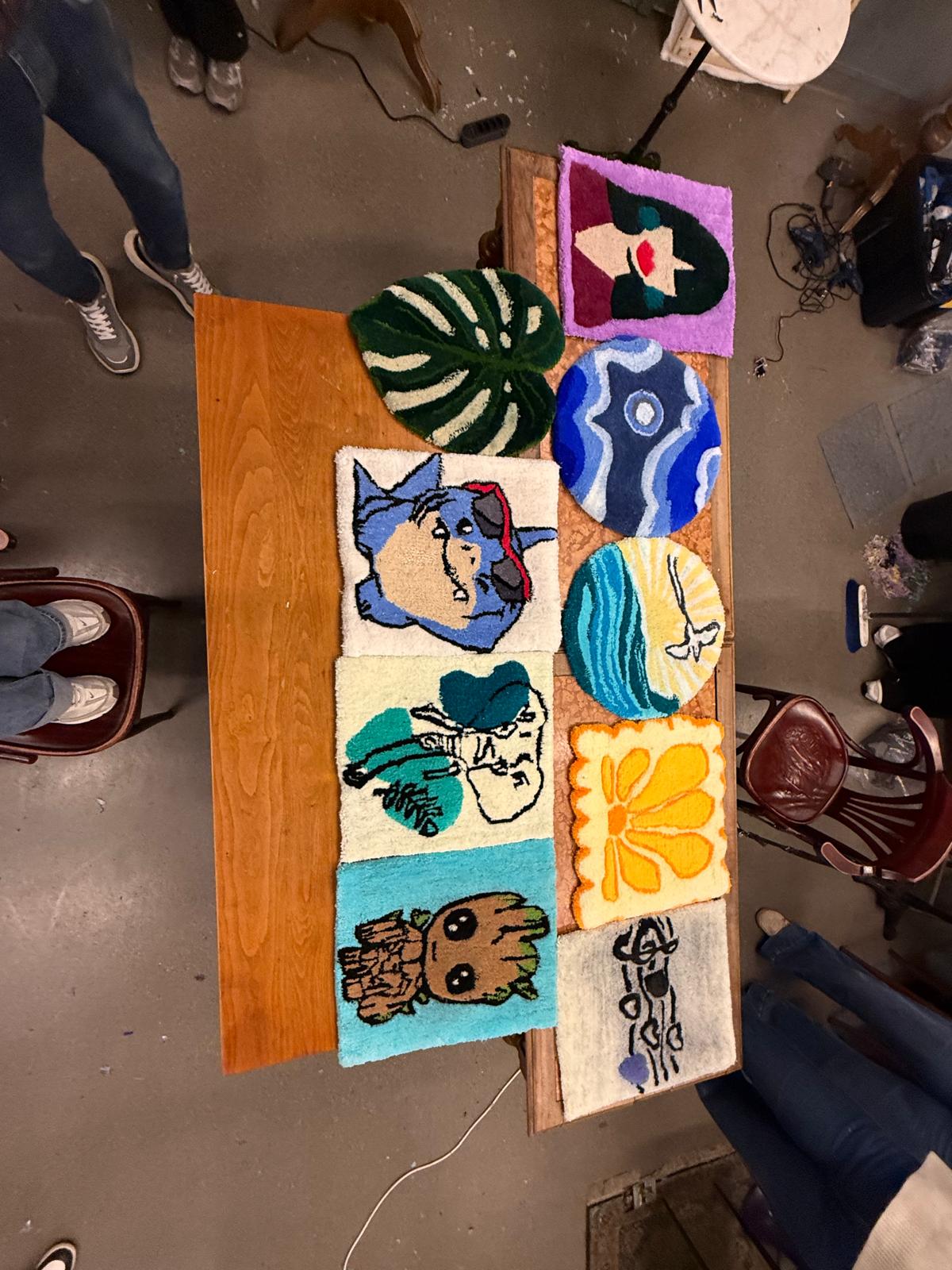 Tapis tuftés colorés réalisés en atelier, posés sur une table